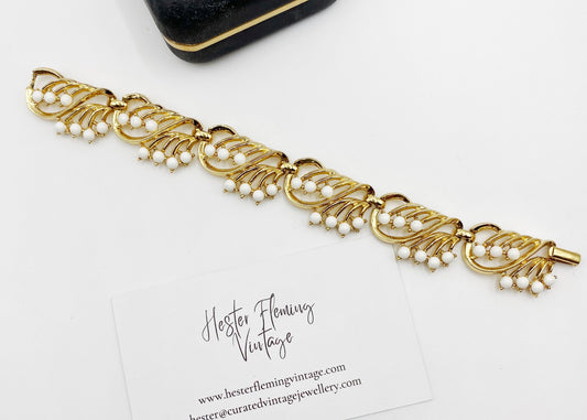 “1950s Crown Trifari gold bracelet with white cabochons, front view.