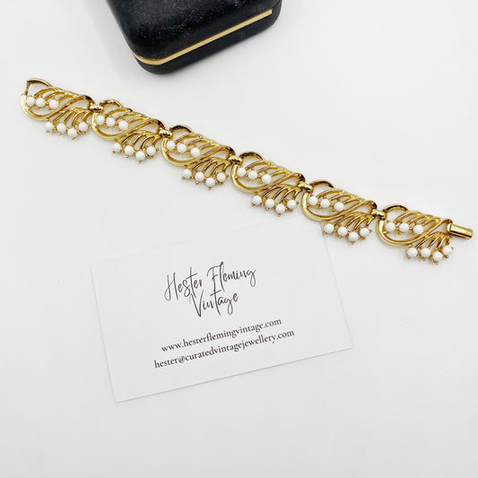 “1950s Crown Trifari gold bracelet with white cabochons, front view.