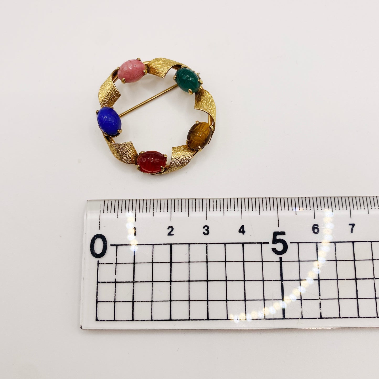 Measurement of engraved coloured glass scarab cabochons on 1960s vintage gold-plated brooch.