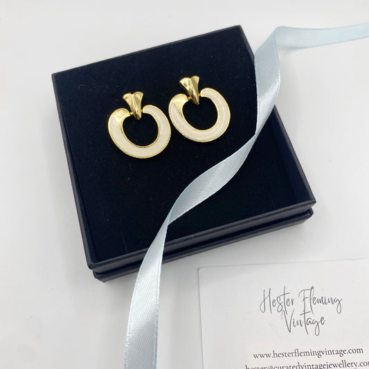 Front view of 1970s vintage cream enamel and 22kt gold plated earrings for pierced ears.