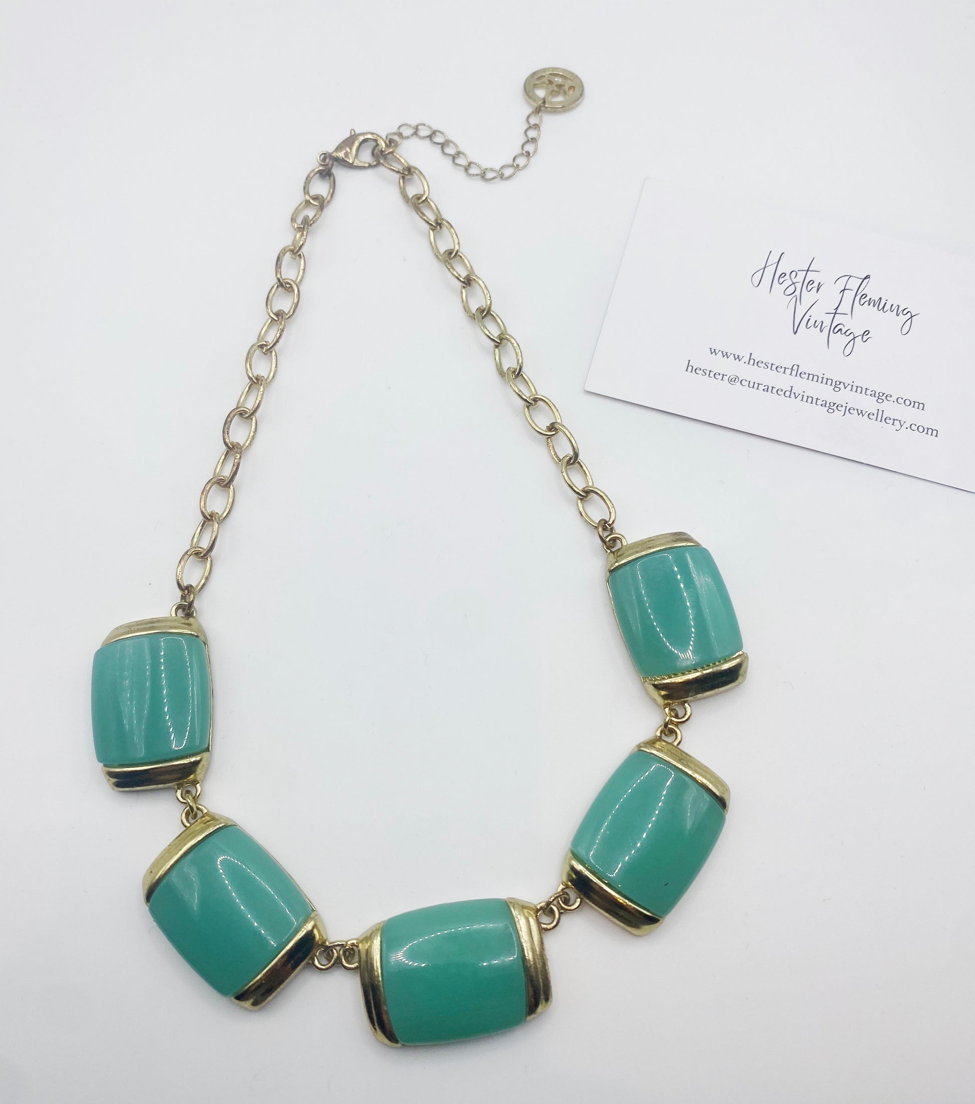 Front view of 1980s Crown Trifari gold-plated necklace with jade green glass panels