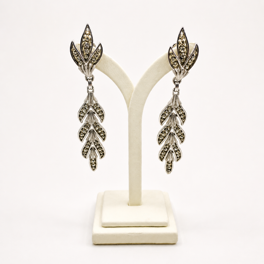 A pair of 1950s Trifari earrings on a jewellery stand.