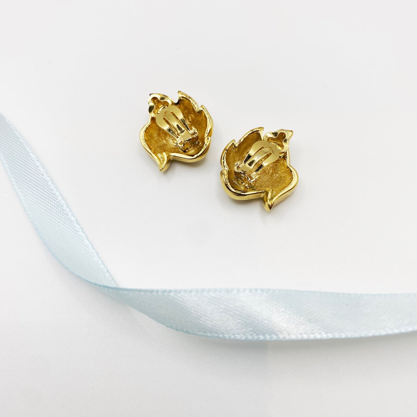 Back of vintage retro earrings from the late 1980s or early 1990s against a neutral background