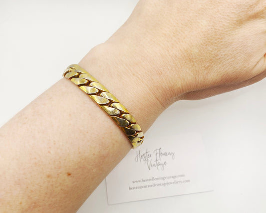 Wrist view of an authentic signed Christian Dior 1970s gold link bracelet