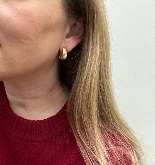 Styled shot of vintage Dior gold earrings on display