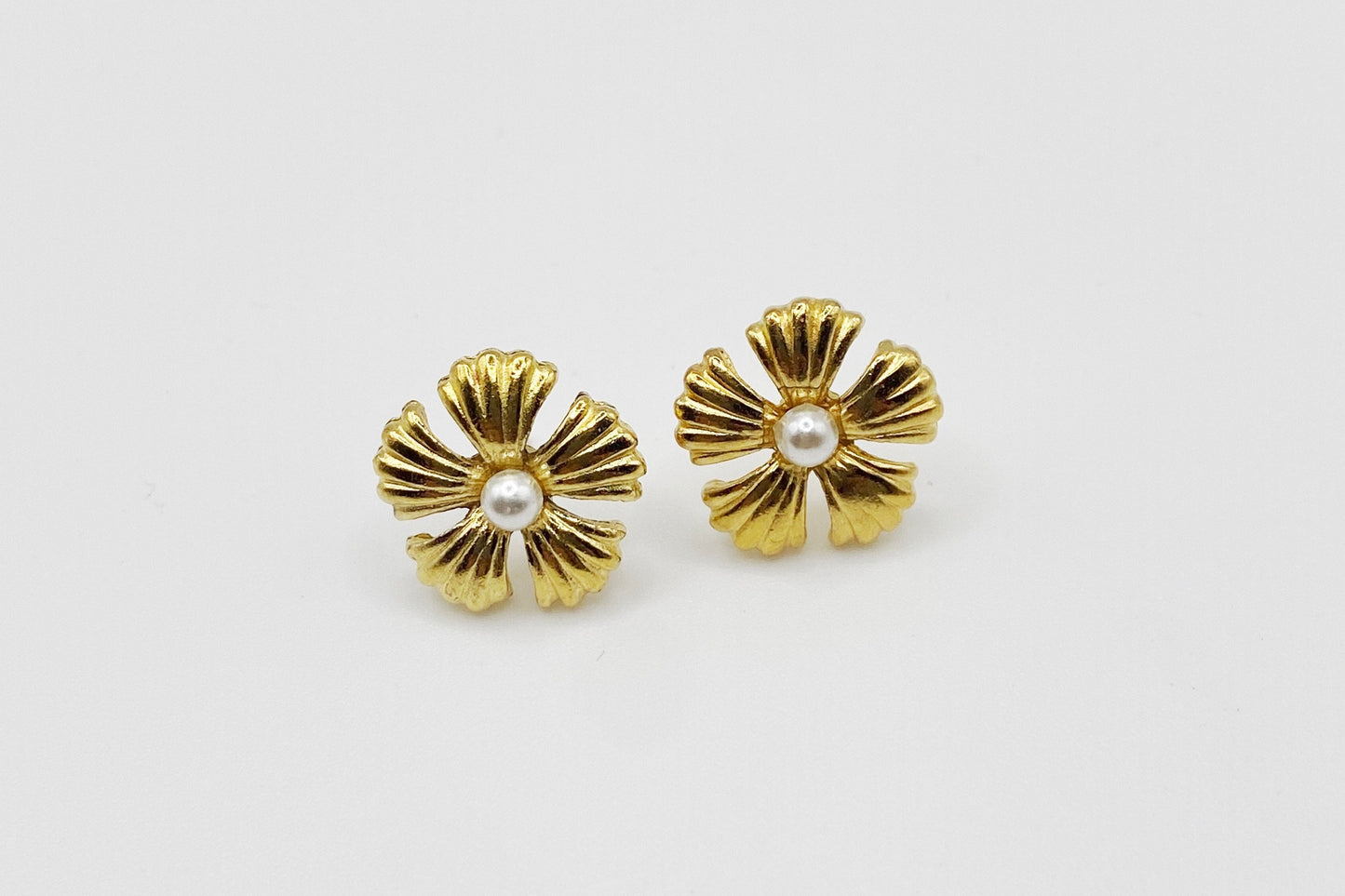 lose-up of 1990s Frayer vintage earrings showing faux pearl centre and textured 22kt gold plating.