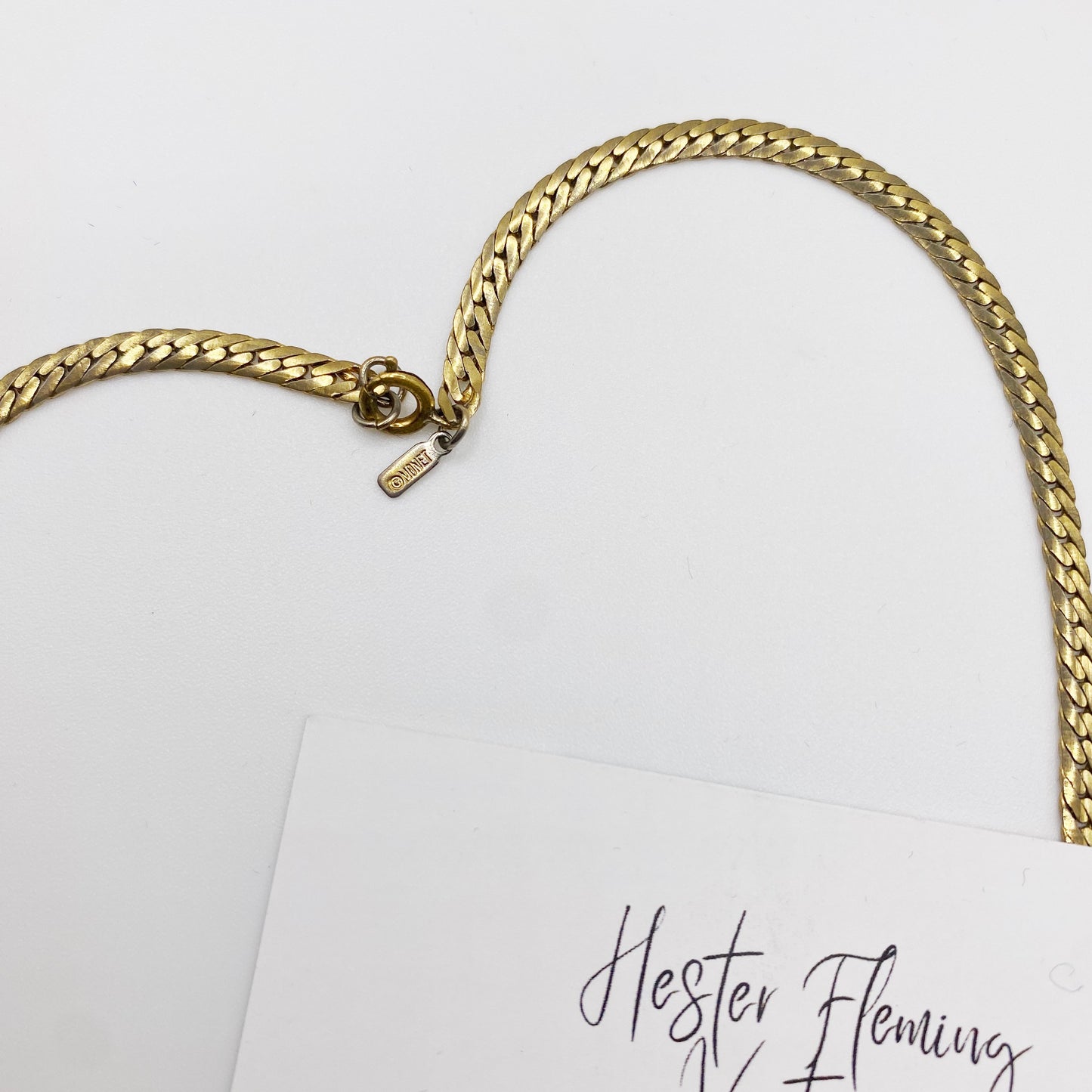 Monet necklace brand tag on a white background with 'Hester Fleming' branding.