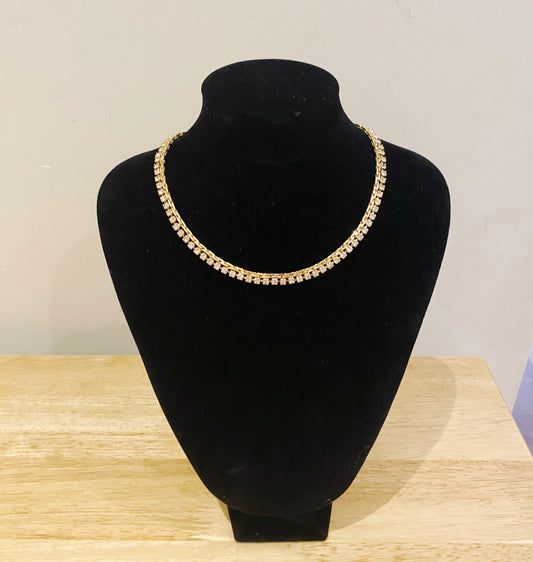 Close-up of Swarovski crystals set in 22kt gold plated vintage necklace on jewellery stand.