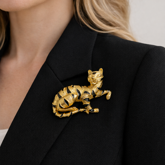 Vintage Trifari tiger brooch in gold tone metal with black enamel stripes, shown on jacket