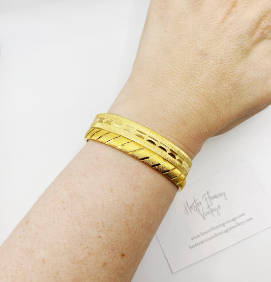 Close-up of vintage Monet gold bangles showing high-quality gold plating