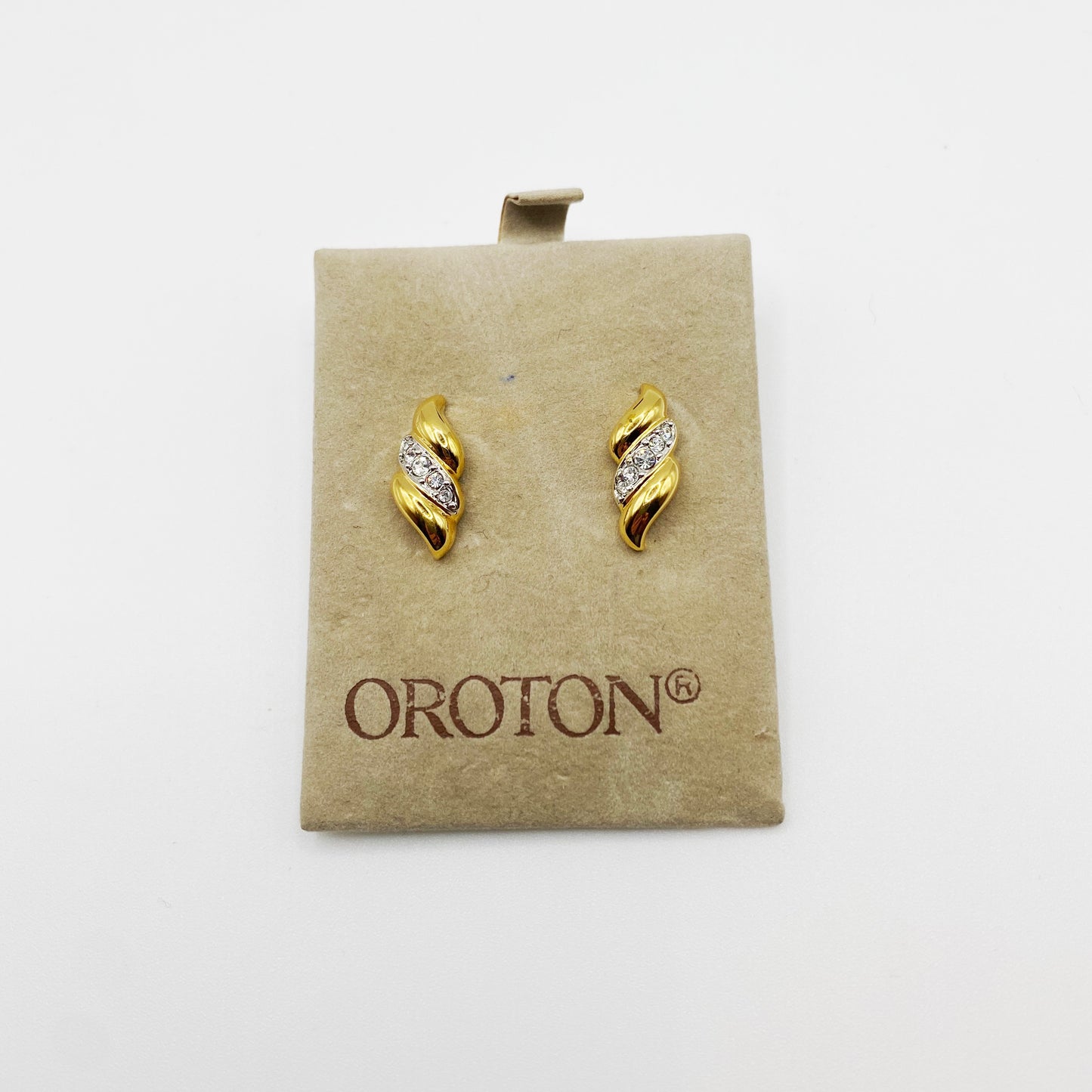 Pair of vintage Oroton swirl earrings with Swarovski crystals from the 1990s (plain background).