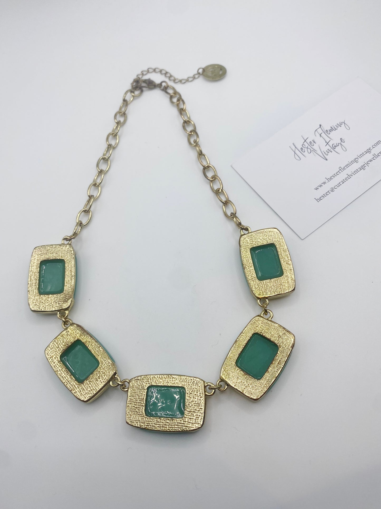 back view of vintage Trifari necklace showing jade green glass detail and gold finish.