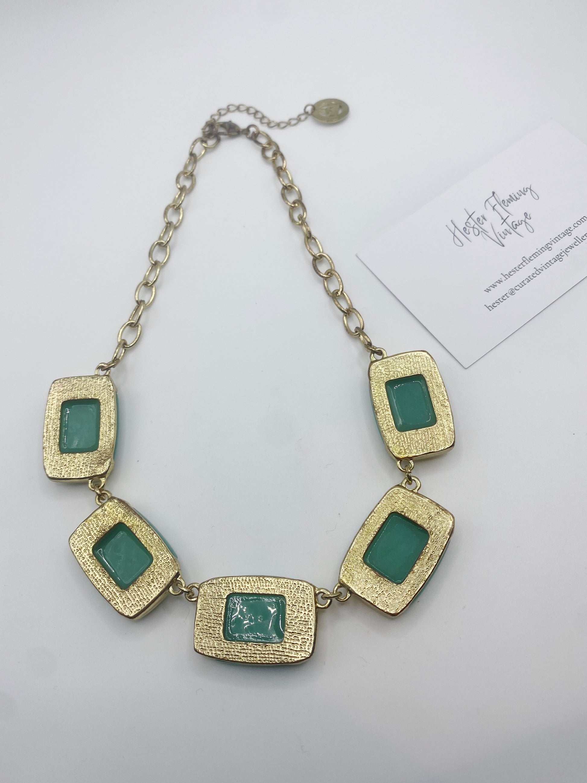 back view of vintage Trifari necklace showing jade green glass detail and gold finish.