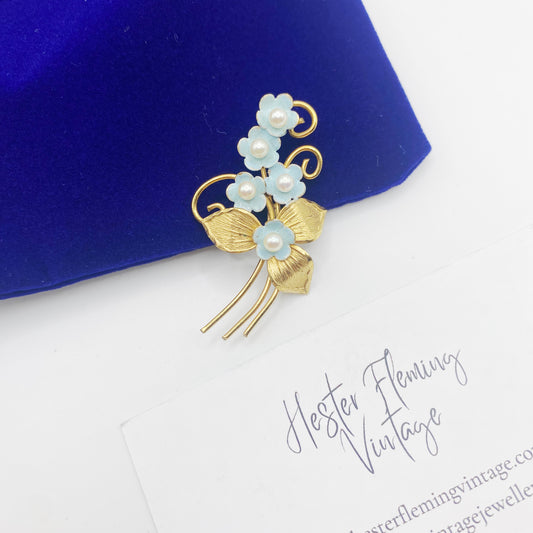 Front view of 12KT gold filled forget-me-not brooch with blue enamel flowers and pearl centres