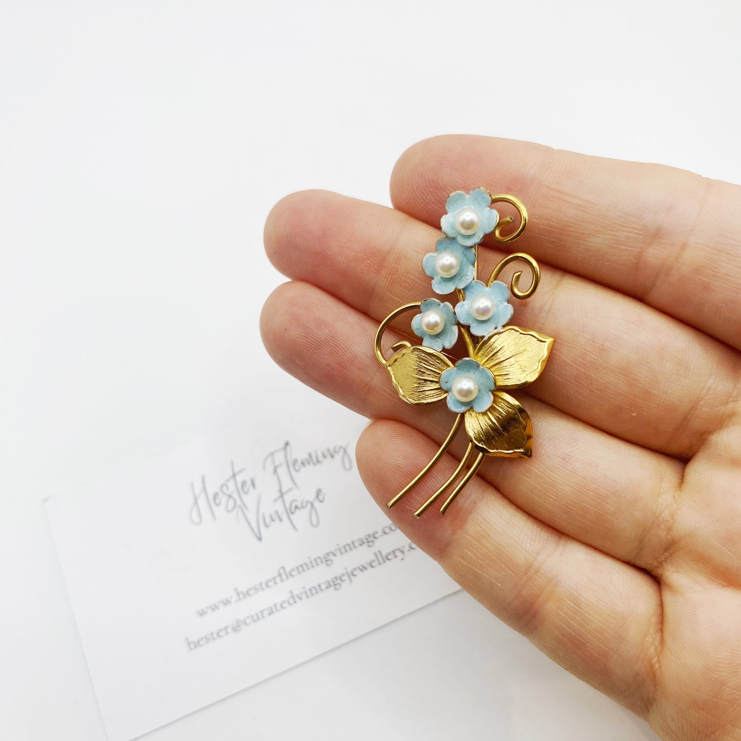 Vintage 1950s gold filled floral brooch shown in hand for scale