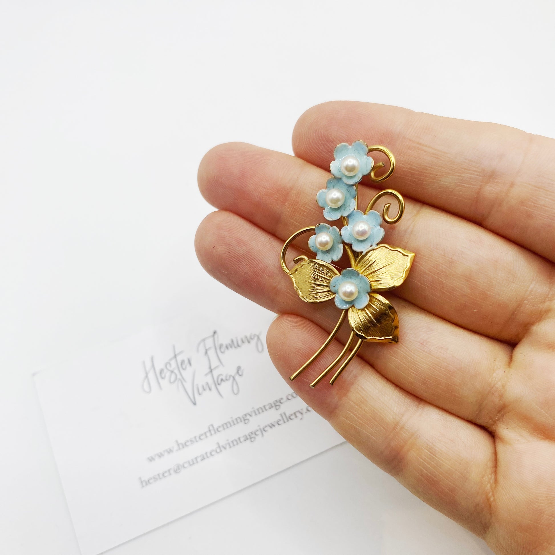 Vintage 1950s gold filled floral brooch shown in hand for scale