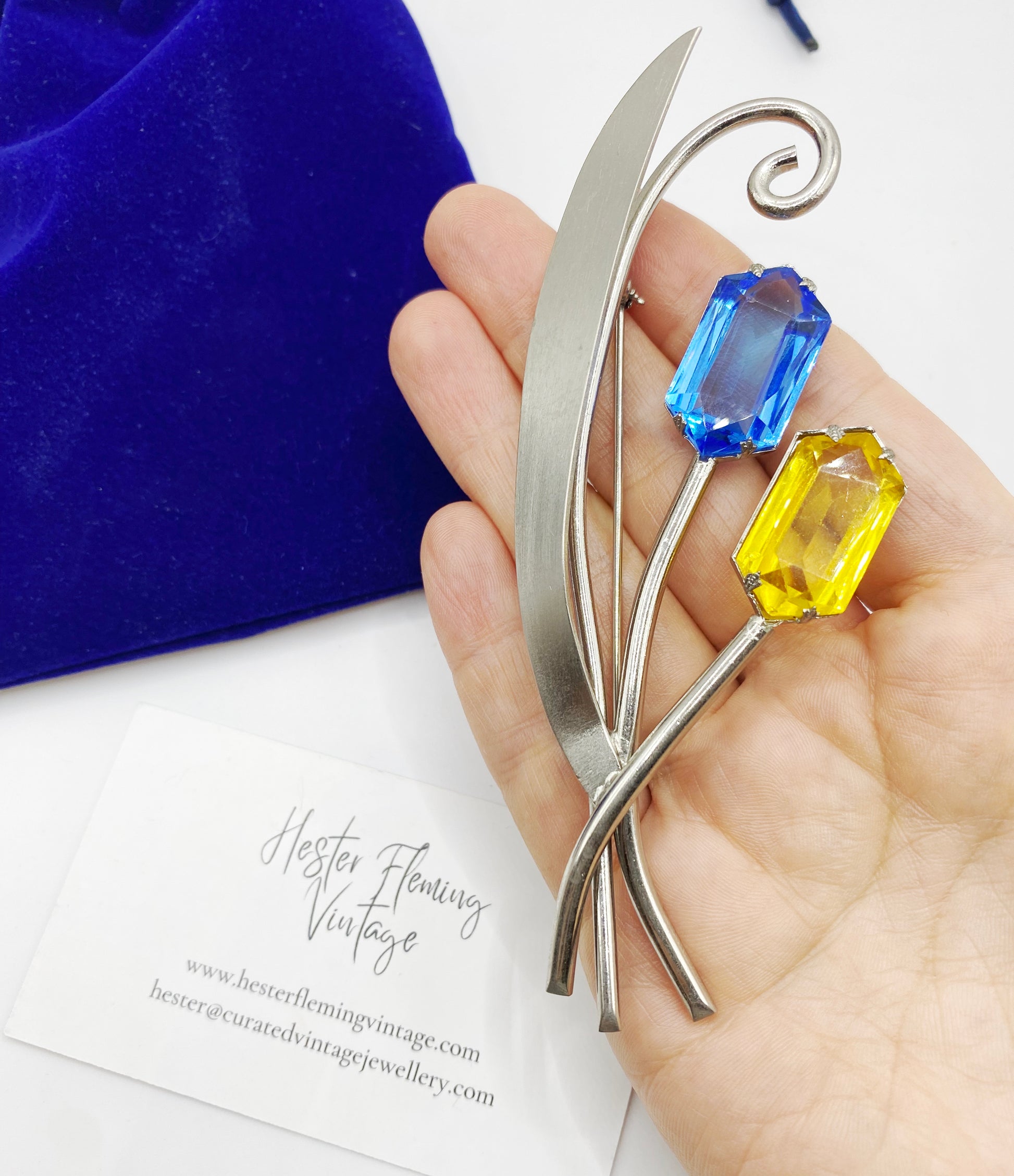 1940s Silvertone and crystal brooch placed on hand for scale. 