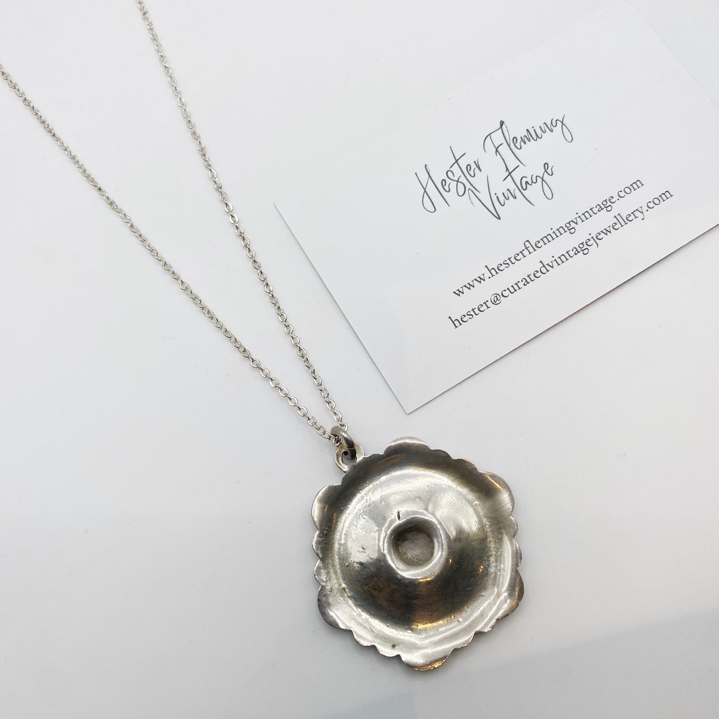 Back view of 1950s Danish enamel pansy pendant showing silver setting and hollow construction