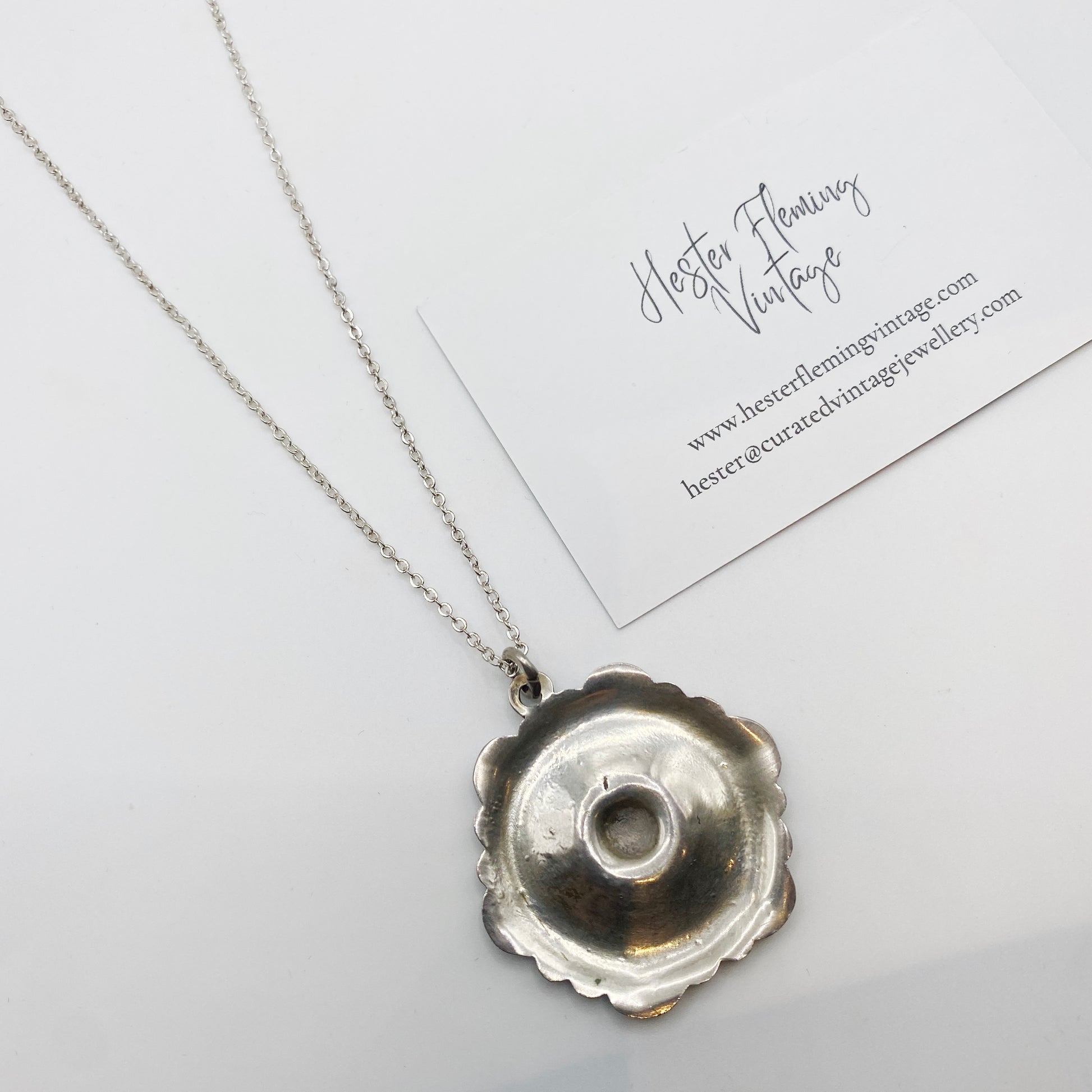 Back view of 1950s Danish enamel pansy pendant showing silver setting and hollow construction