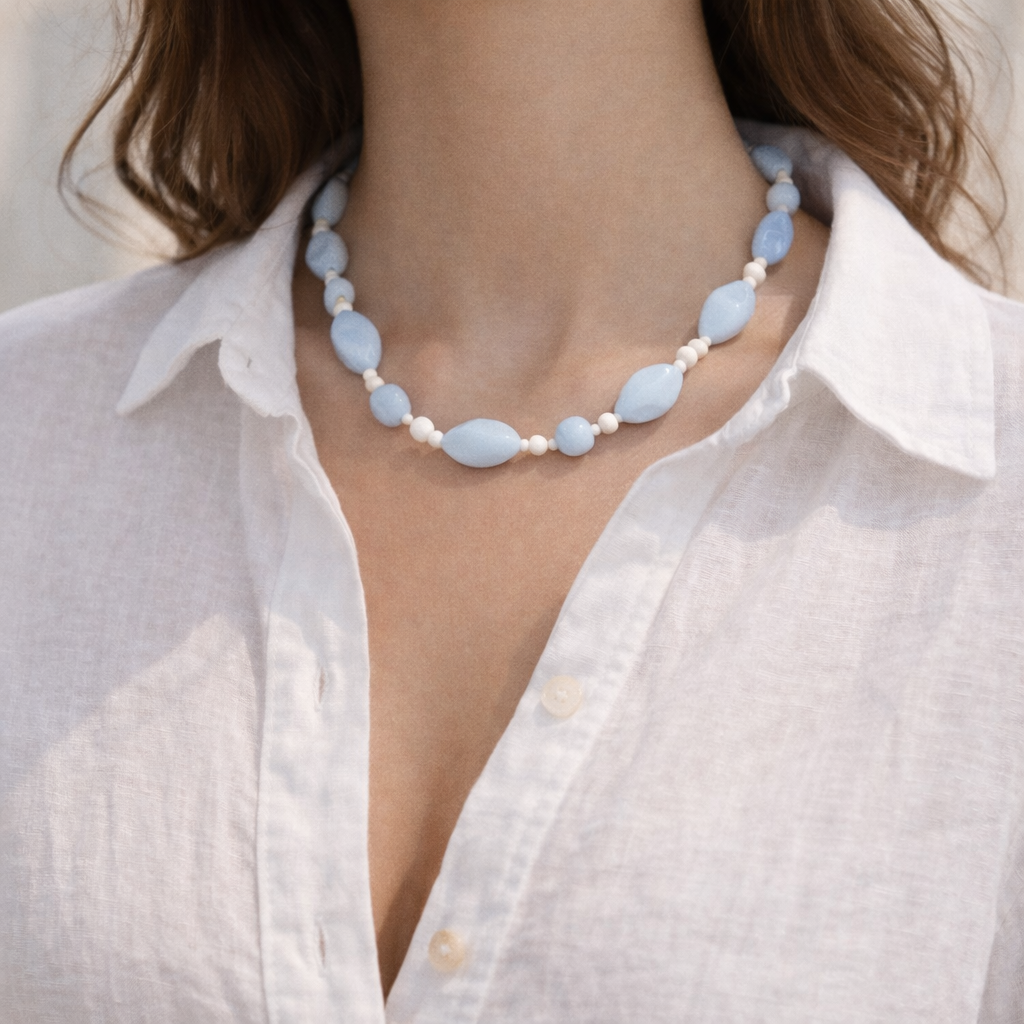 1950s vintage powder blue glass bead necklace, styled on a model wearing a white linen shirt.