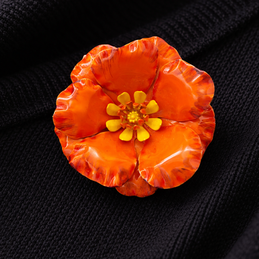 1960s Enamel poppy brooch styled on black knit. 