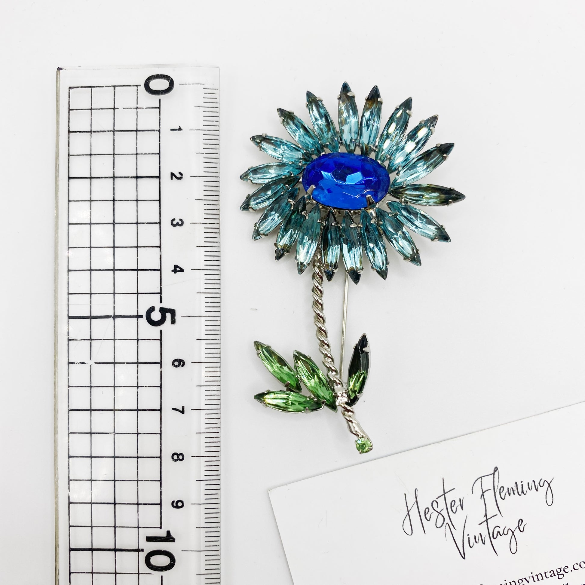 1960s Floral Rhinestone Brooch placed next to a ruler for scale. 