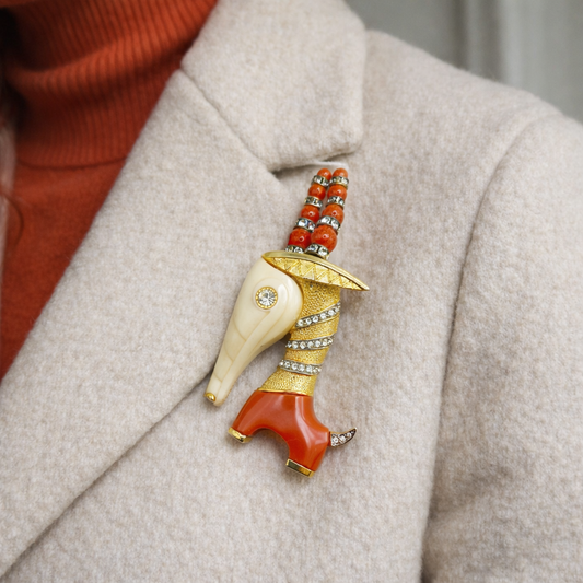 1960s Hattie Carnegie Capricorn Brooch styled on a cashmere jacket.
