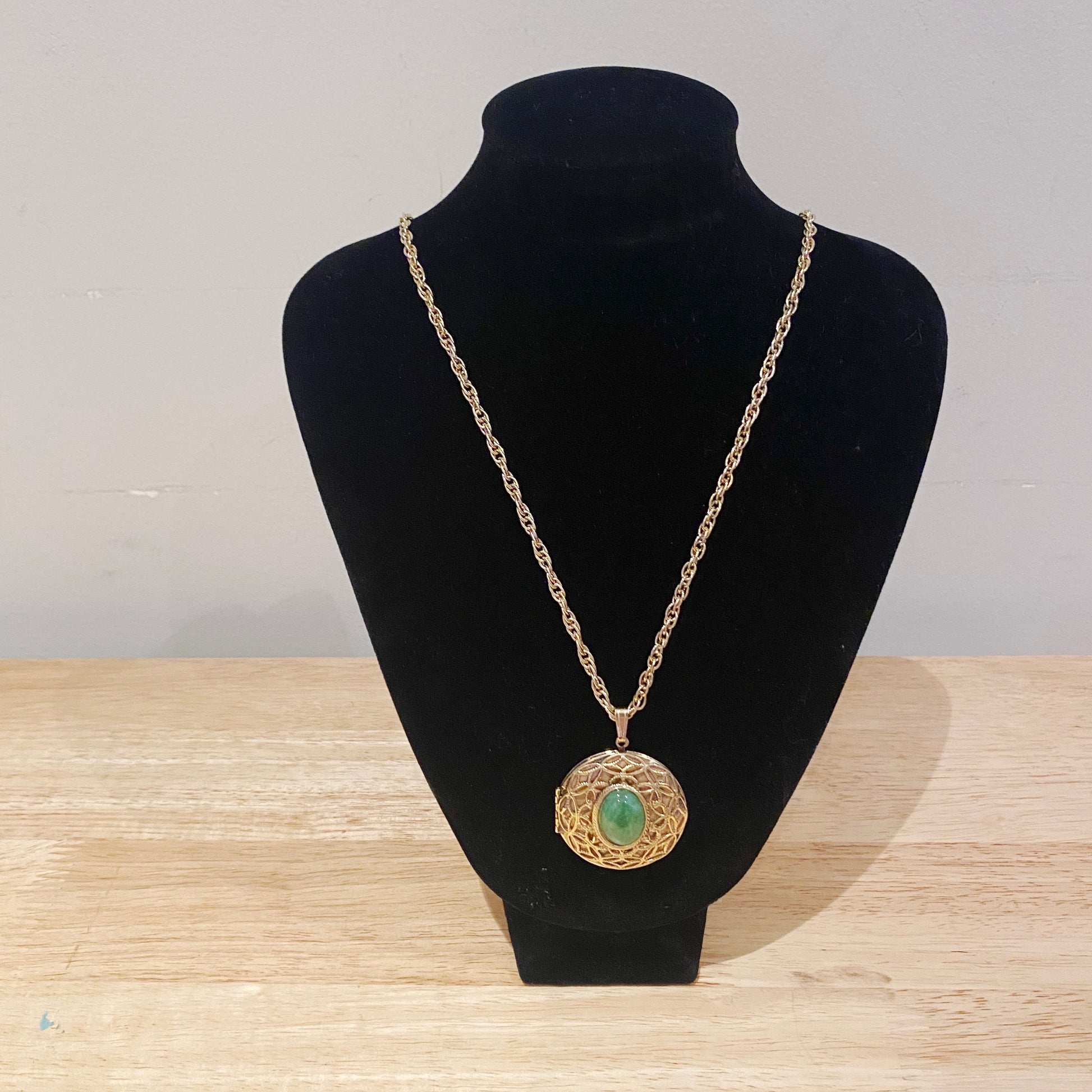 Vintage locket necklace on jewellery stand.