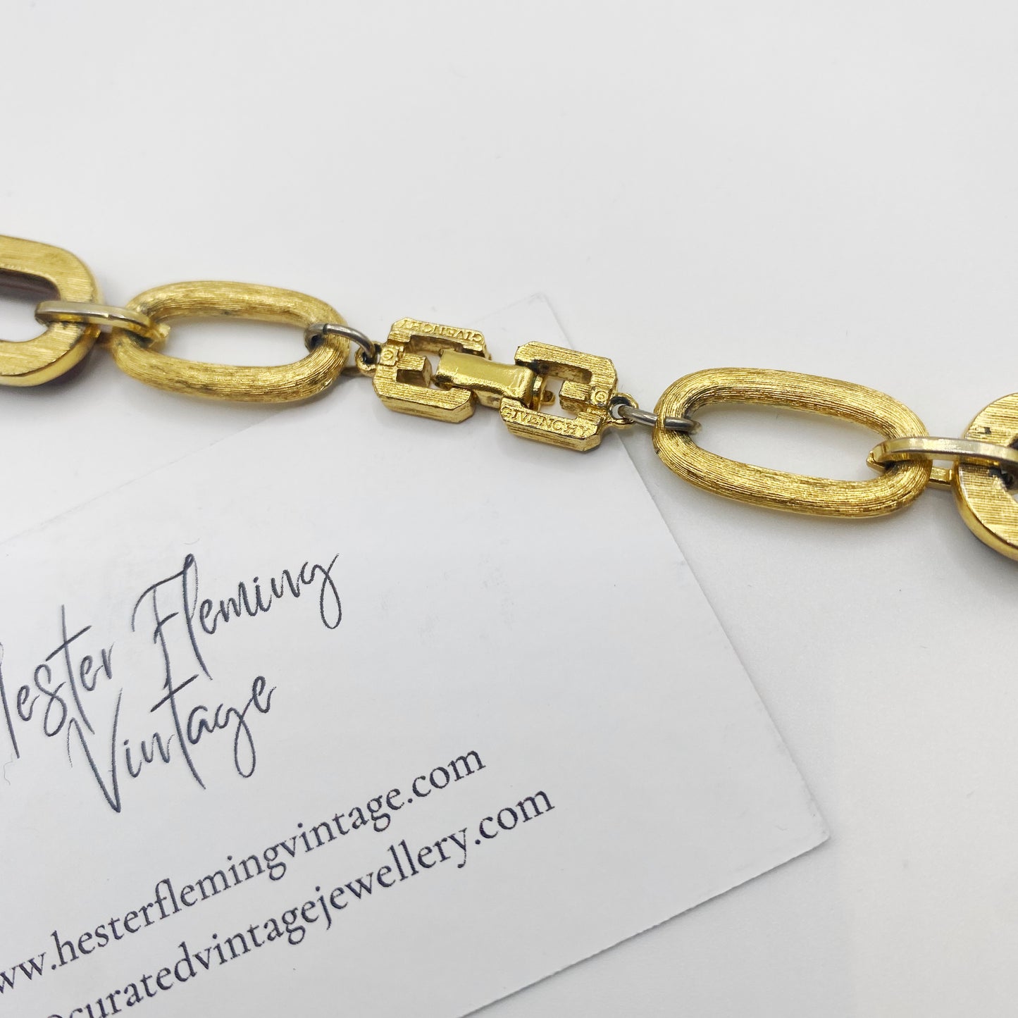 Close-up of signed 1970s Givenchy gold tone clasp on tortoiseshell link statement necklace.