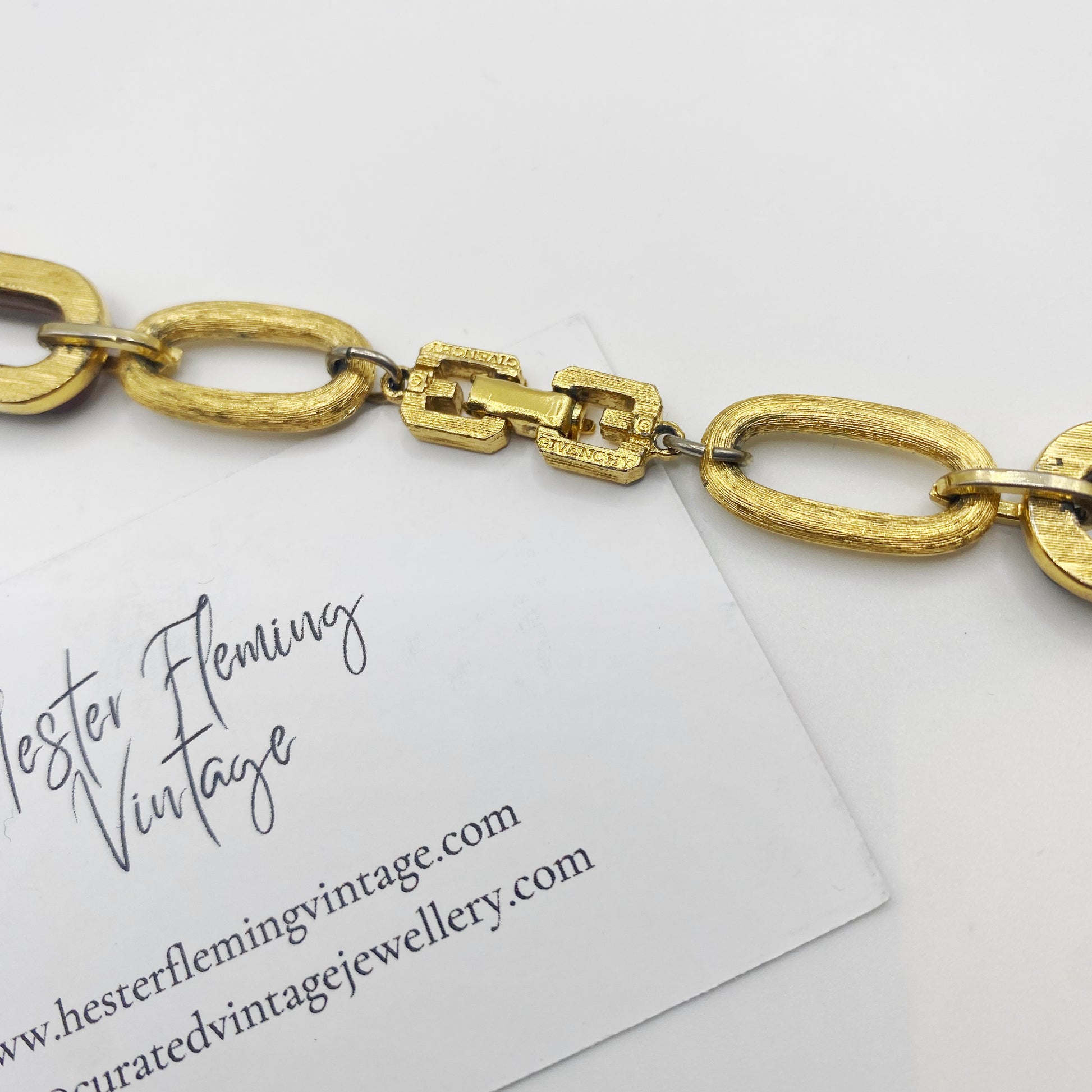 Close-up of signed 1970s Givenchy gold tone clasp on tortoiseshell link statement necklace.