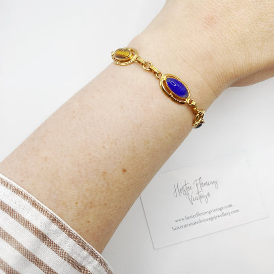 Wrist view of 12KT gold-filled scarab bracelet with carved gemstones