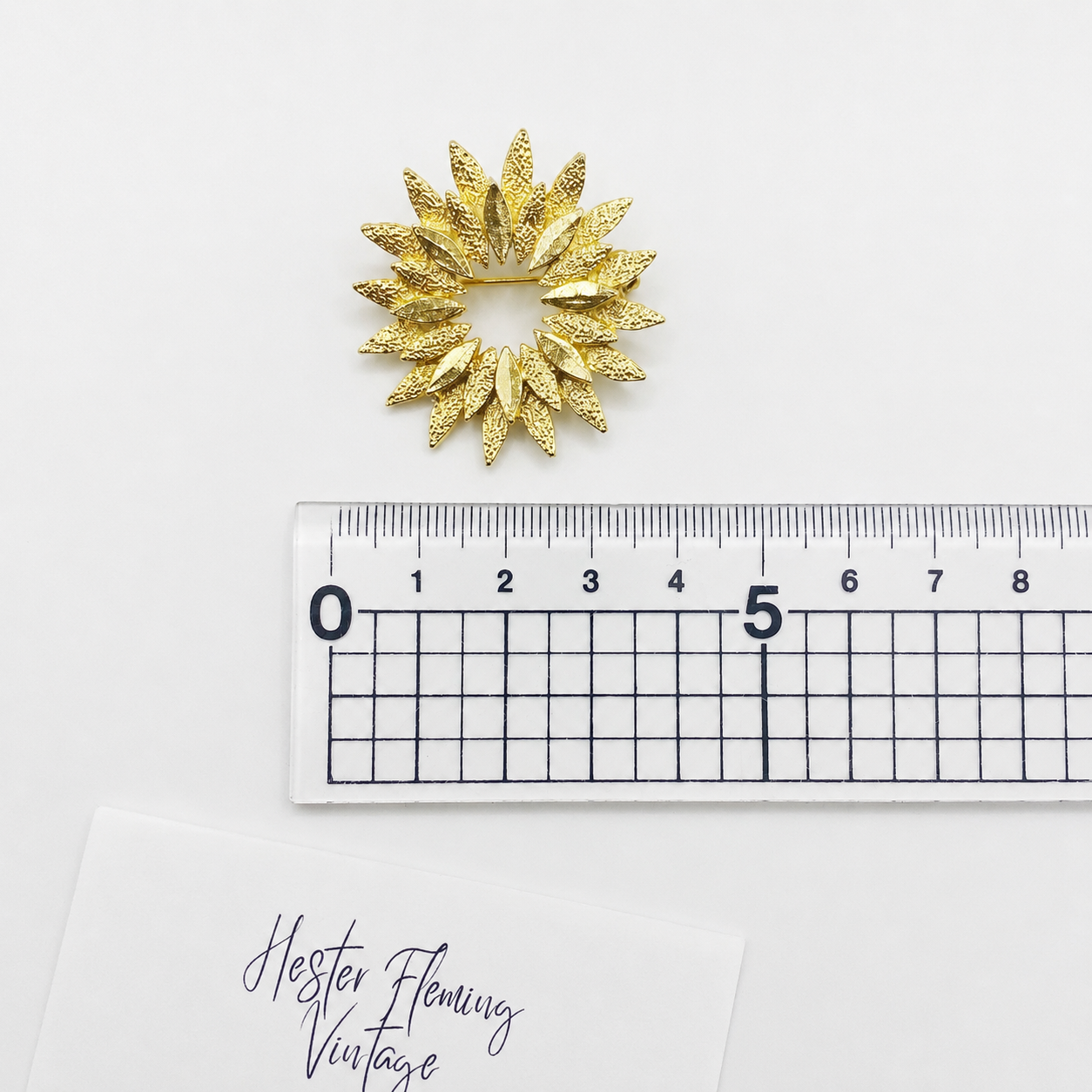 1970s Sunburst Brooch, placed next to a ruler for size. 3.5cm x 3.5cm 
