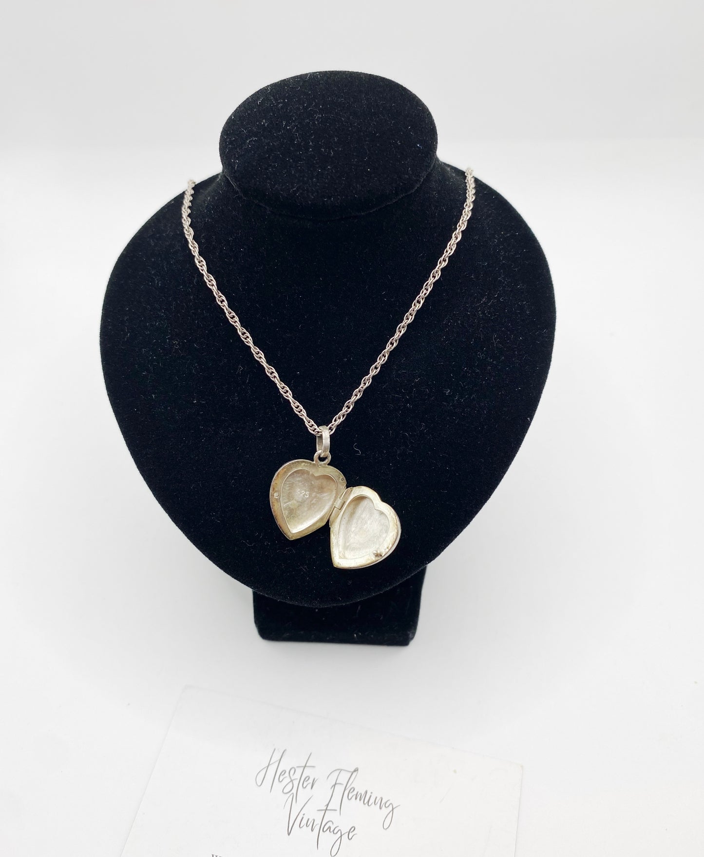 Circa 1980s sterling silver heart locket necklace shown open on display bust
