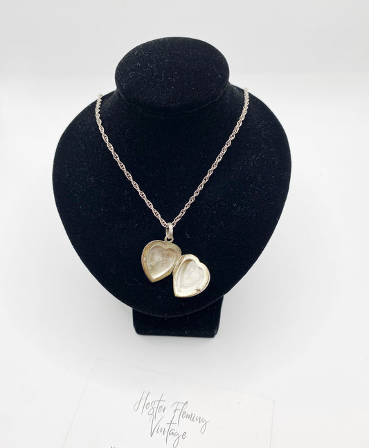 Circa 1980s sterling silver heart locket necklace shown open on display bust