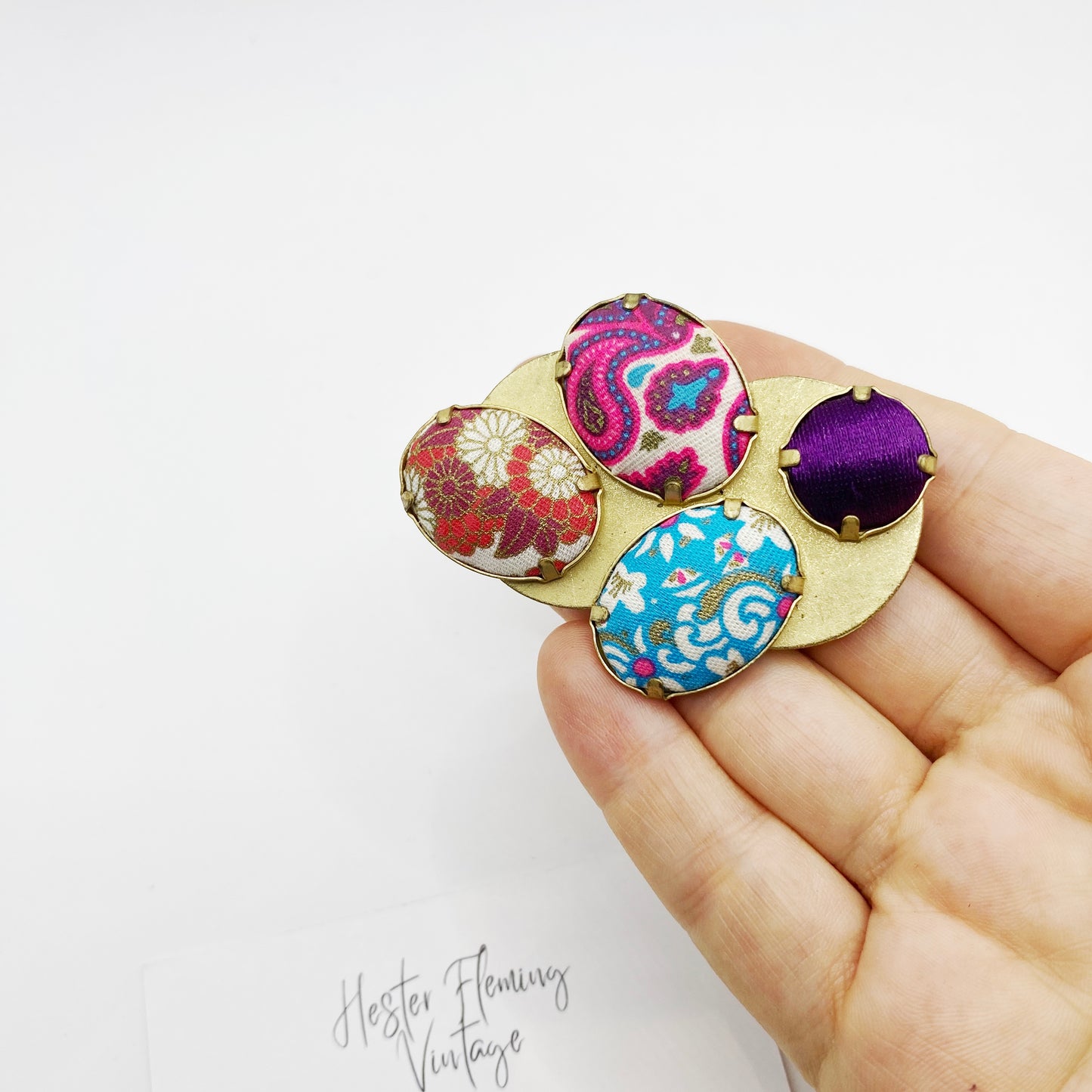 1980s 1990s Kenzo brooch shown on hand for scale.