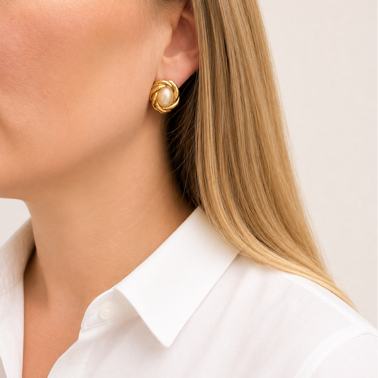 1980s Gilt knot and pearl earrings, styled on a model, wearing a crisp white shirt.