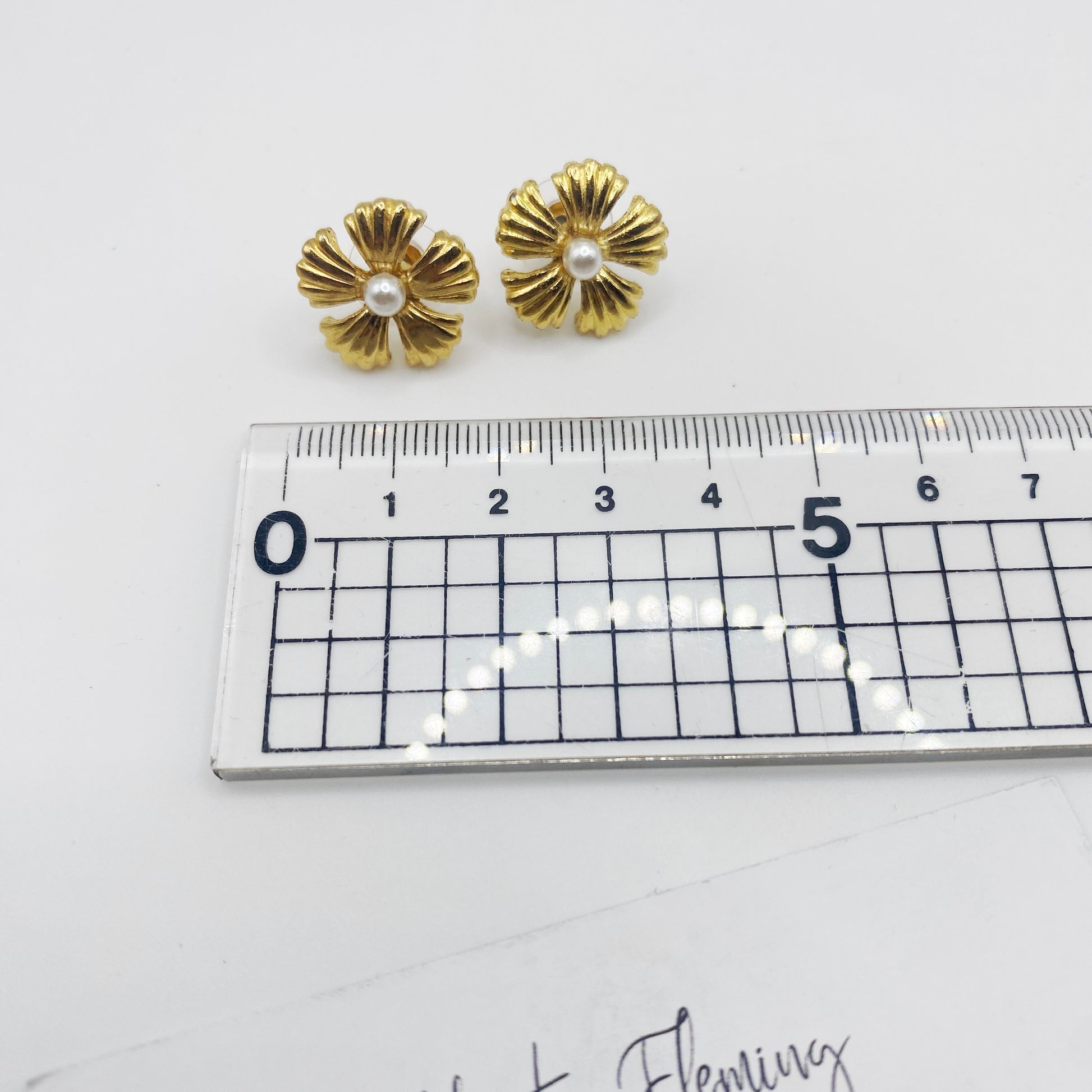 Vintage 90s gold flower earrings shown with ruler for scale