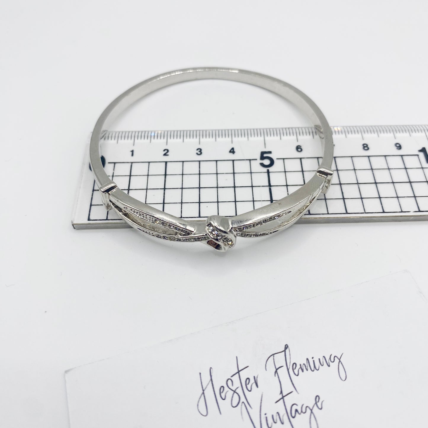1990s silvertone hinged bangle shown with ruler for scale