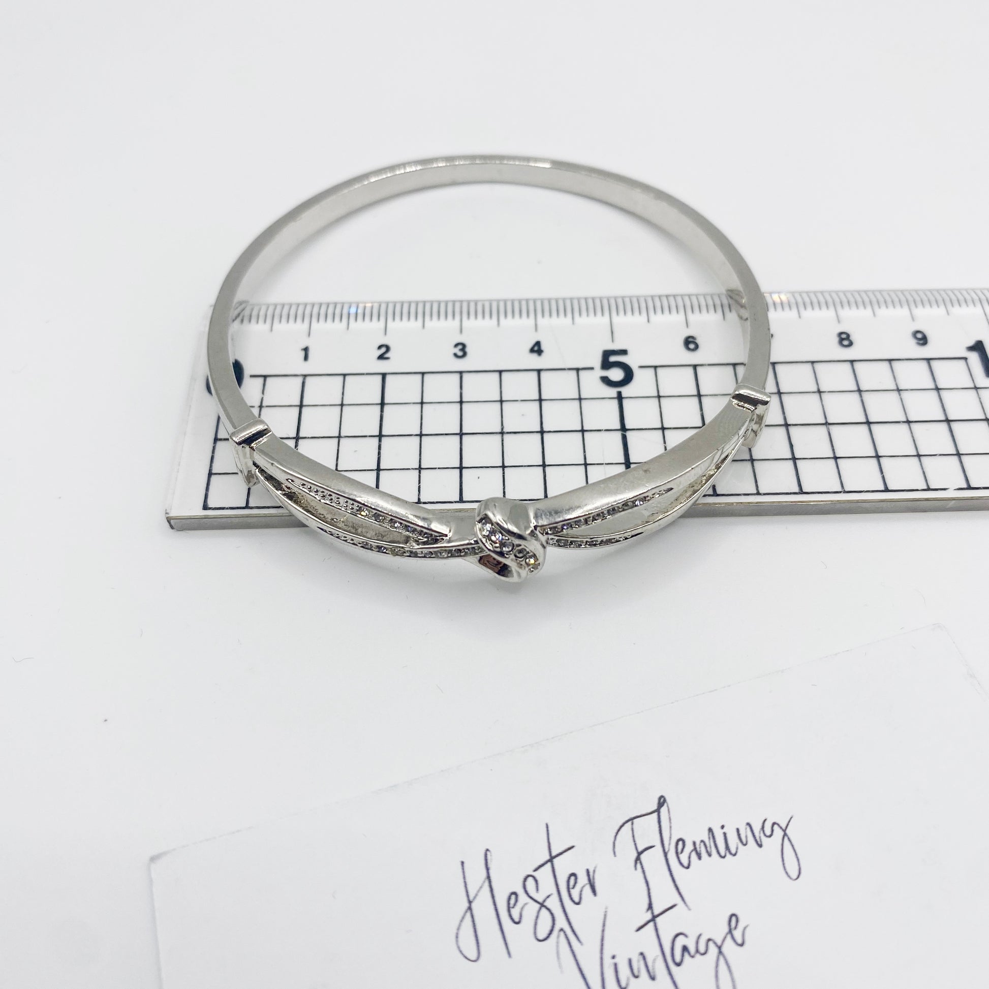 1990s silvertone hinged bangle shown with ruler for scale