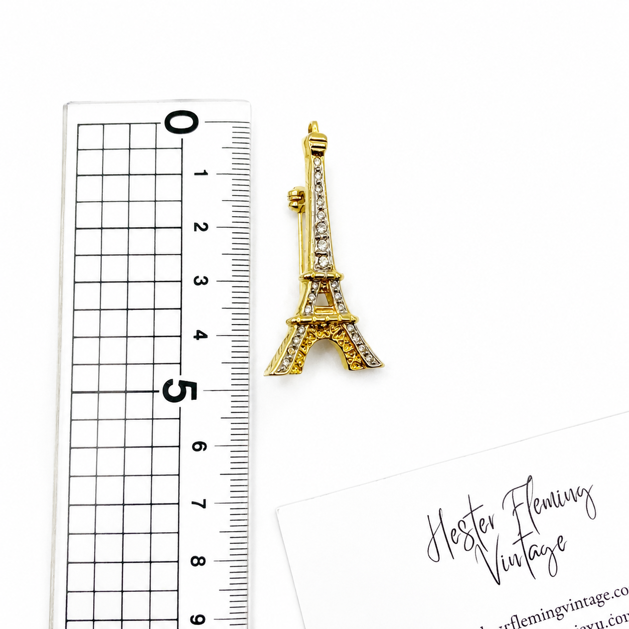 Vintage 1990s Eiffel Tower Brooch, placed next to a ruler for measurement. 