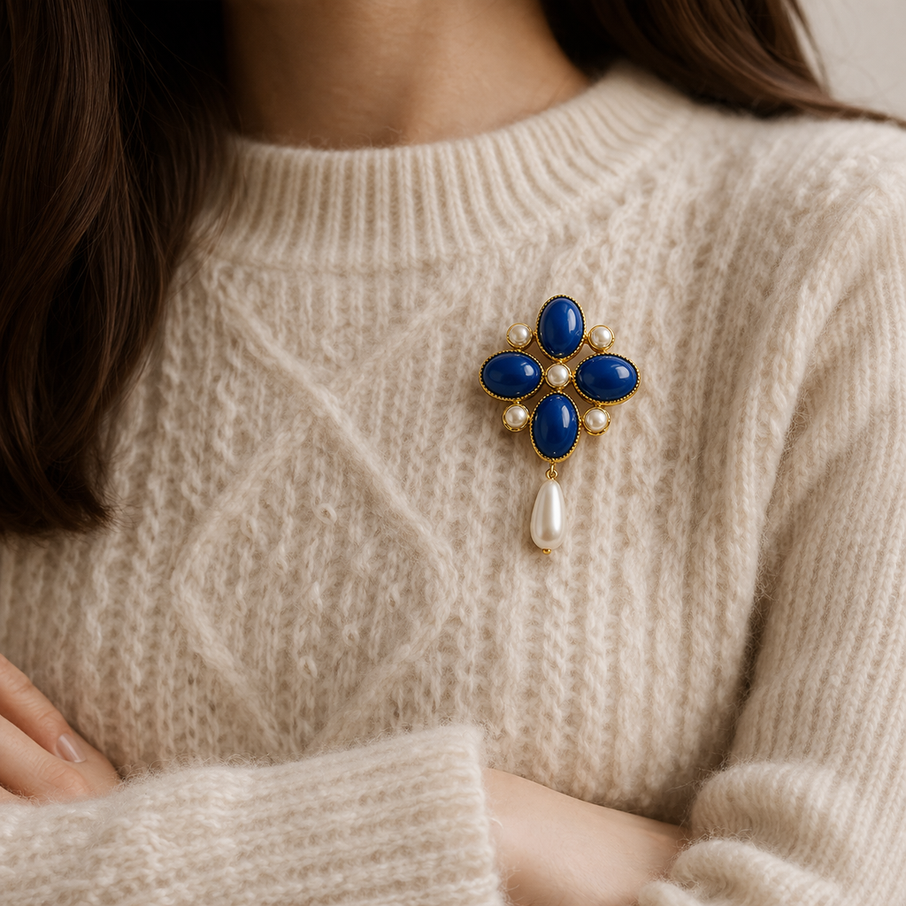1990s Vintage maltese cross brooch with a pearl drop, styled on a knit.