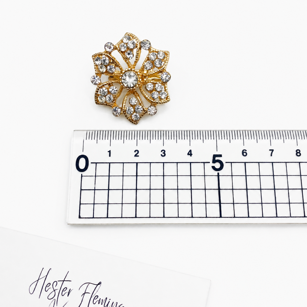 90s Floral Crystal Brooch, placed next to a ruler for size. 3cm x 3cm. 