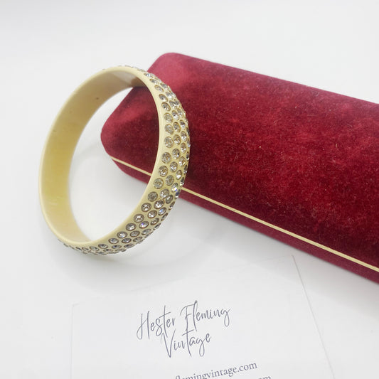 Antique deco flapper bangle displayed with a red velvet jewellery box. 