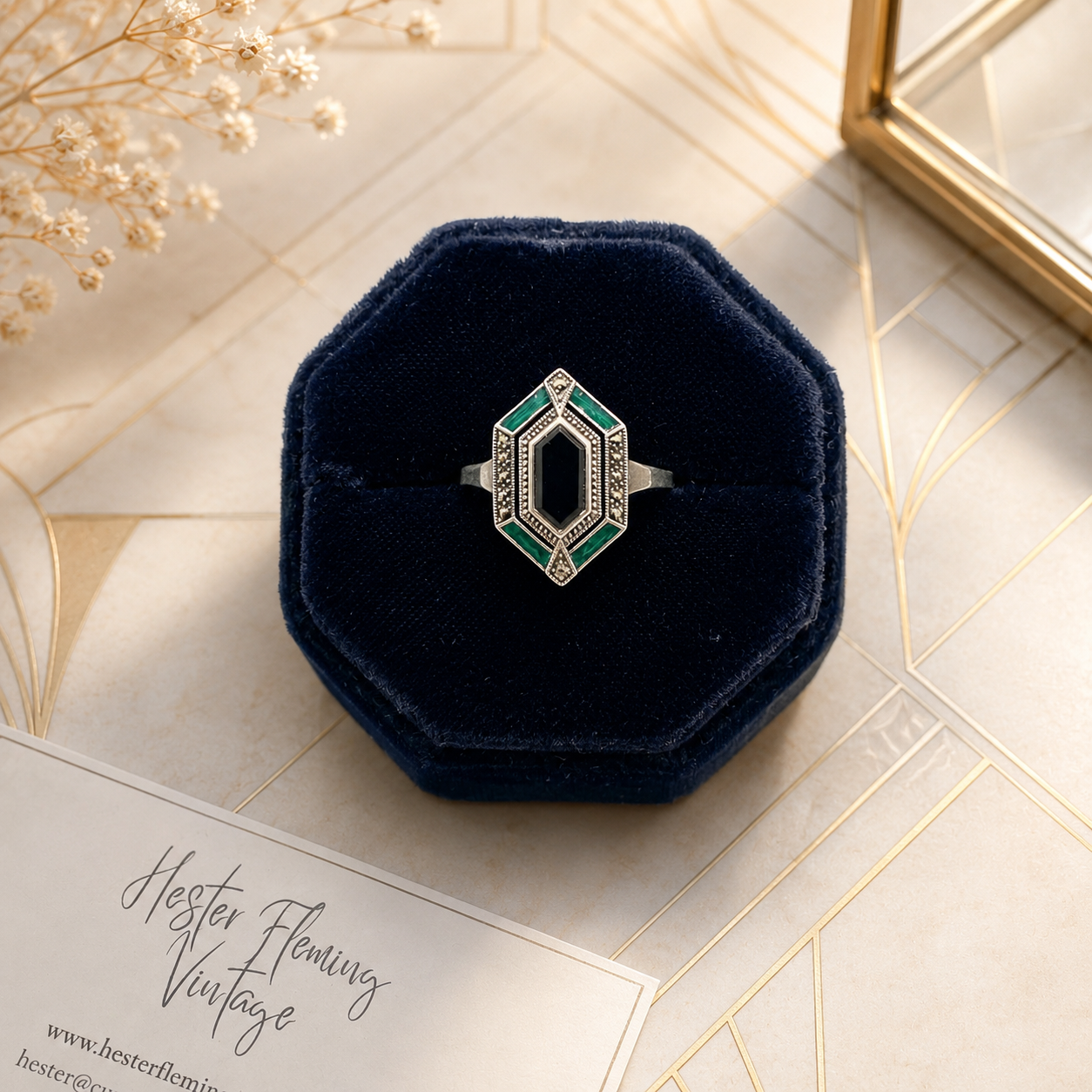 Ring presented in velvet box. Art deco background. 