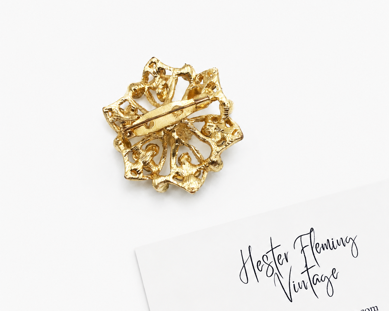 Back view of 90s floral crystal brooch. 22kt gold plating. Roll clasp. Good vintage condition. 