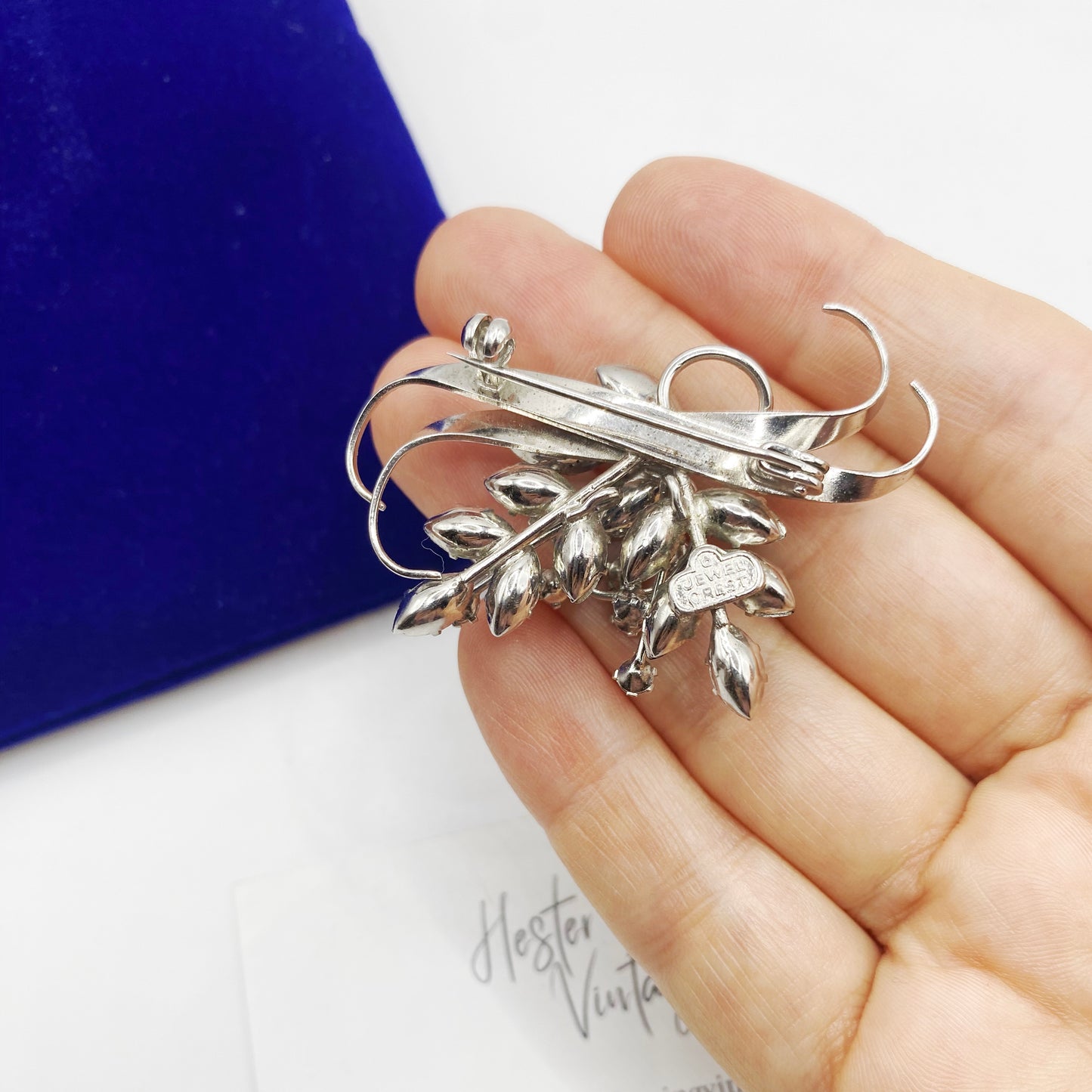 Back view of rhodium plated jewelcrest brooch. 