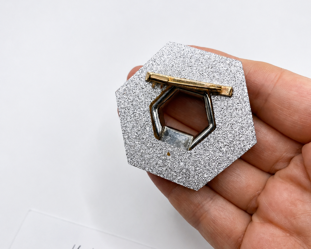 Back view of 1980s French pink lucite deco brooch on hand. 