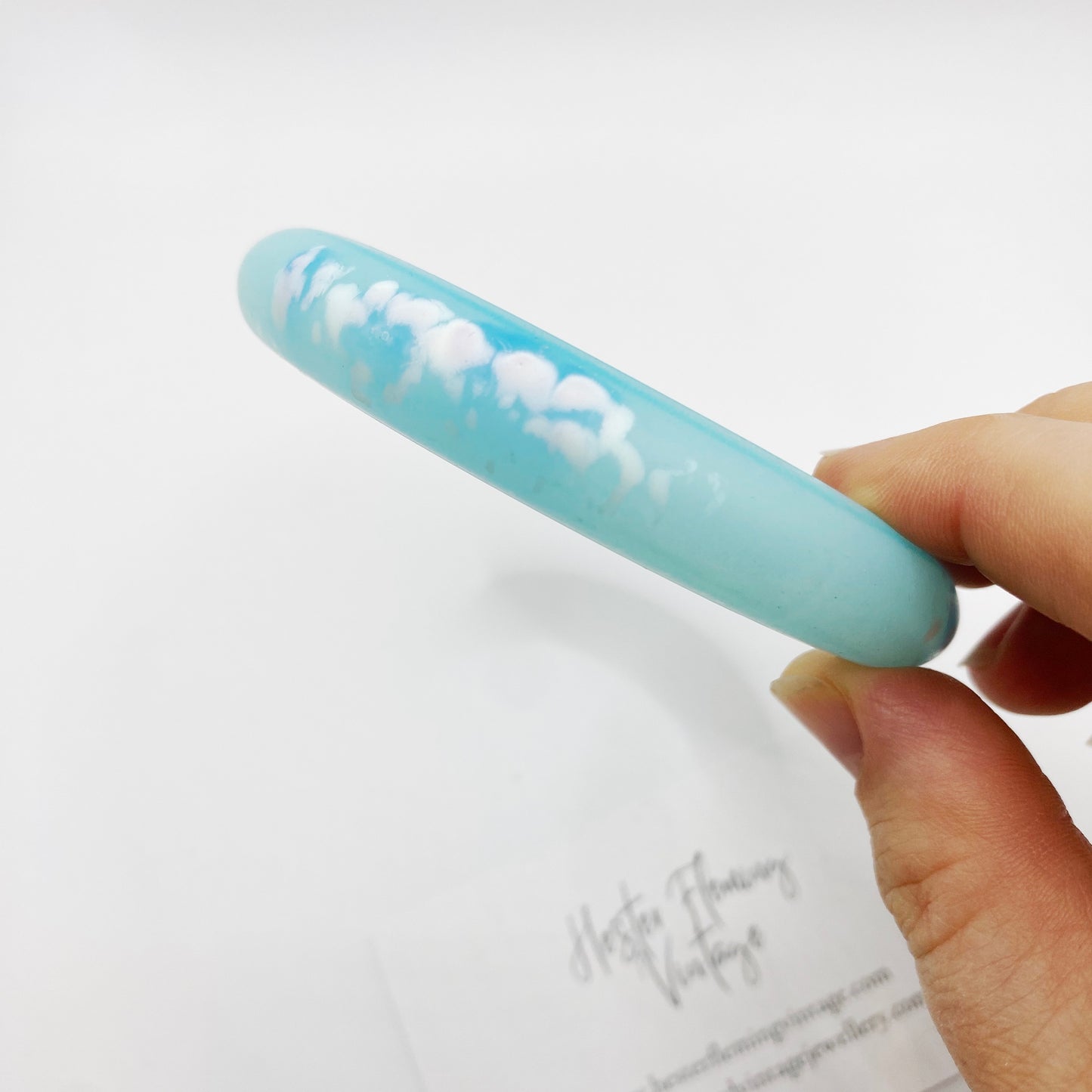 Close up of Vintage 80s Blue Polymer Bangle. White marbling decoration.