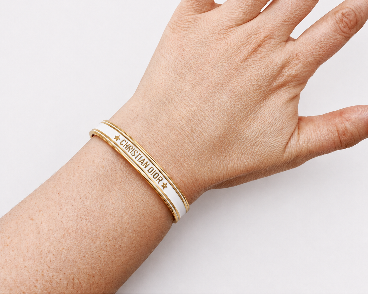 White enamel, Dior bangle shown on wrist. 