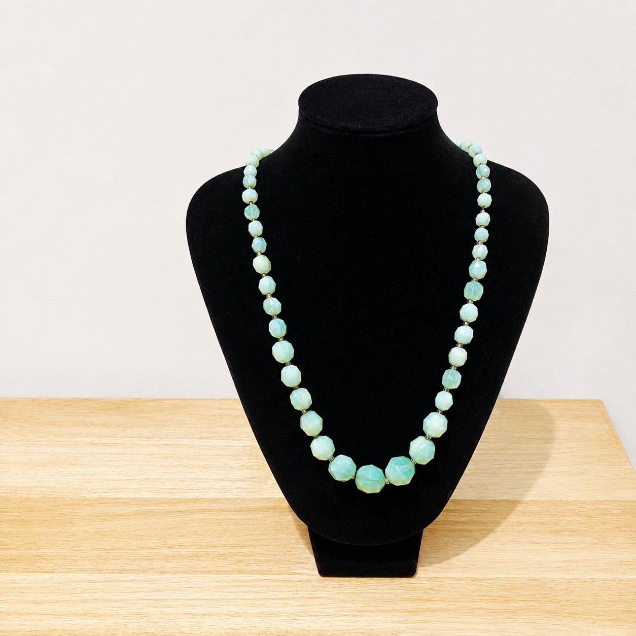 French deco milk glass beads, displayed on a velvet jewellery bust. 